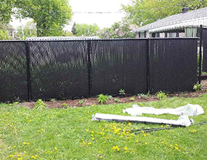 Installation de clôture Frost noire en maille de chaine 6 pieds de haut, avec installation de lattes intimité, travaux effectués a Boucherville sur la rive-sud de Montréal